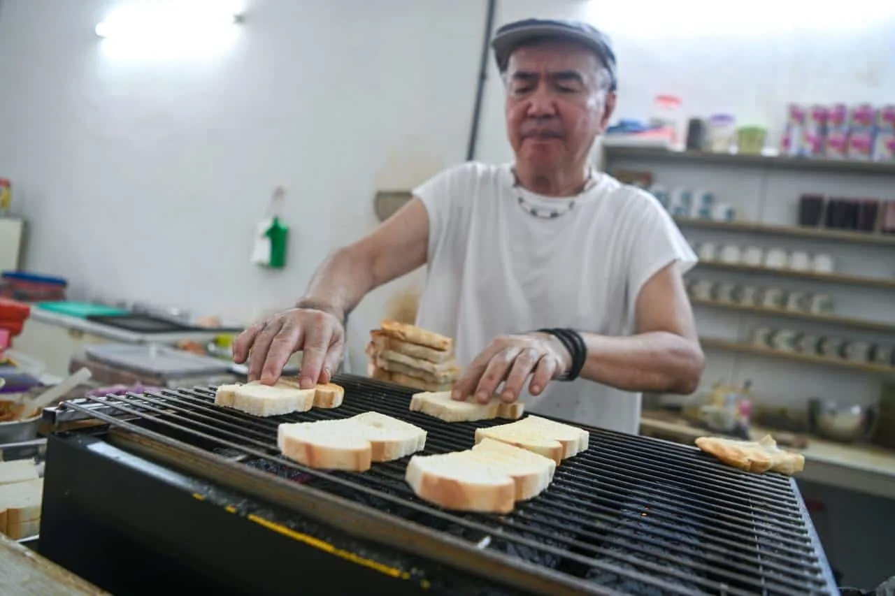 Bread over the charcoal grill — the shop toasts to order rather than using an electric toaster. Photo: Siew Chia En/Buletin Mutiara